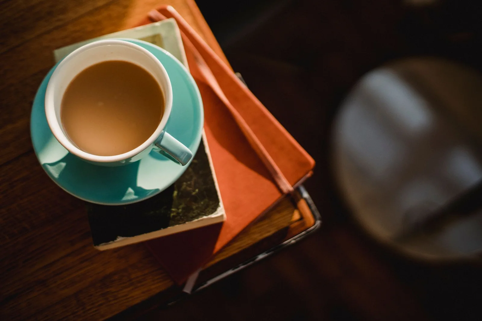 Conceptual overhead scene of a coffee cup resting on stacked books